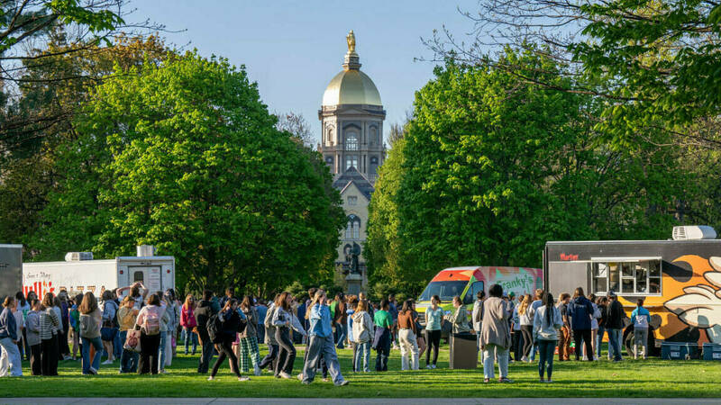 Students participating in food truck event on the South Quad in front of the Golden Dome