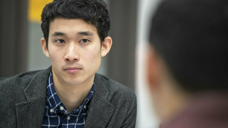 Staff member listening intently to someone out of frame in front of him