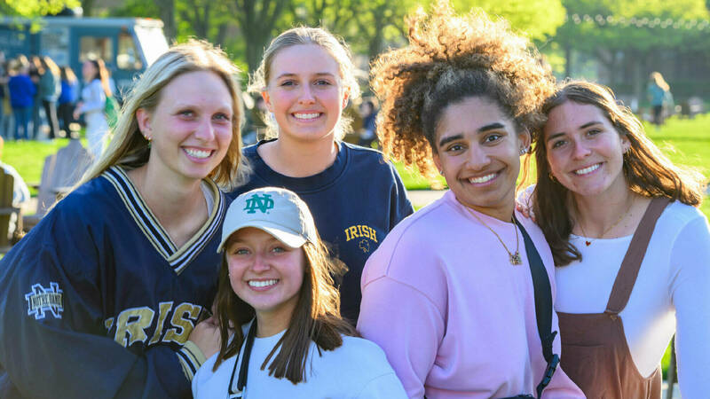 A group of female students posing for a photo on the quad